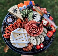 a person holding a platter filled with halloween food