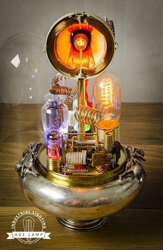 an electronic device sitting on top of a wooden table next to a glass dome with lights inside