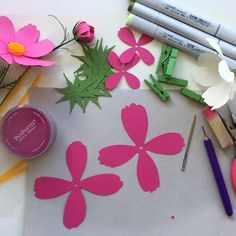 paper flowers and crayons are on the table