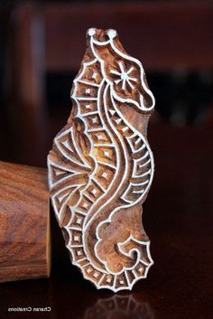 an intricately carved wooden brooch sits on a table