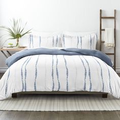 a bed with blue and white comforters in a bedroom