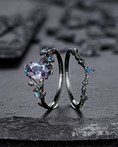 two silver rings with blue stones on them