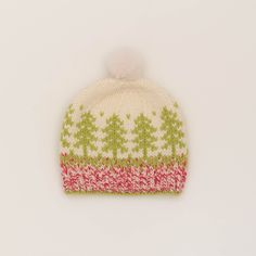 a knitted hat with trees on it and a pom - pom in the center