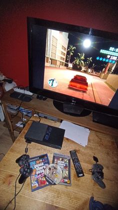 a flat screen tv sitting on top of a wooden table next to a remote control