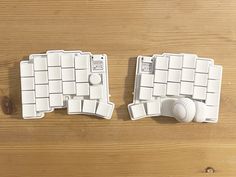 two pieces of white plastic sitting on top of a wooden table next to each other