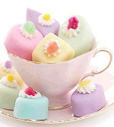 a tea cup filled with different colored desserts