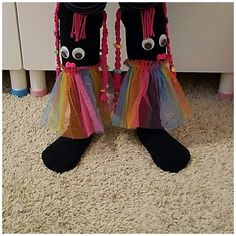 a pair of black shoes with colorful tulle skirt and eyeballs on the feet