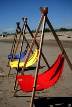 several different colored hammocks on the beach