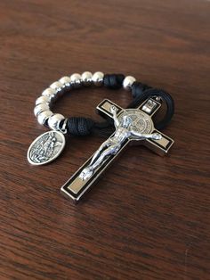 a bracelet with a cross and a medal on it