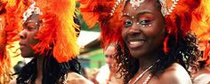 the women are dressed in orange feathers and headdress