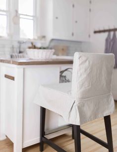 a kitchen with white cabinets and wooden floors