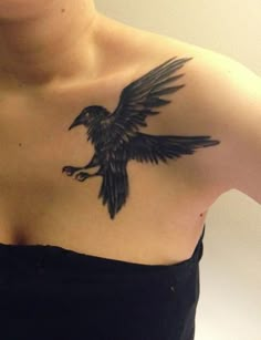 a woman with a black bird tattoo on her chest