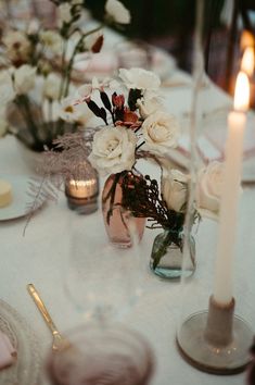 the table is set with flowers and candles