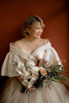 a woman in a wedding dress holding a bouquet