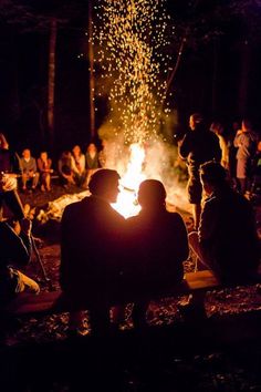 people sitting around a campfire at night