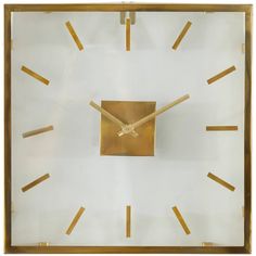 a clock made out of gold sticks with a square shaped face on the front and sides