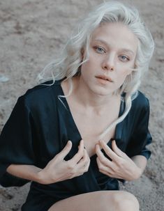 a woman with white hair sitting on the ground