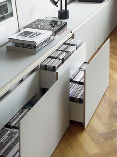 an entertainment center with cd's and cds in drawers on the top shelf next to a window