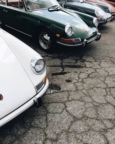 there are many old cars parked in the parking lot with no one around them on the pavement