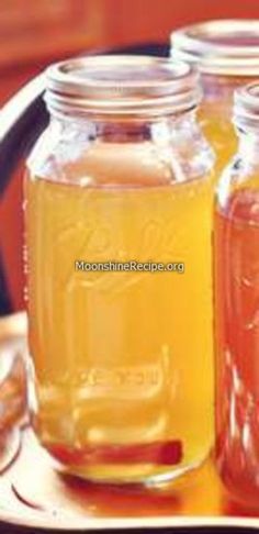 three jars filled with liquid sitting on top of a table