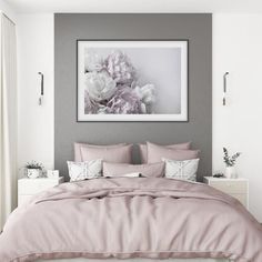 a bed with pink comforter and pillows in a bedroom next to a painting on the wall