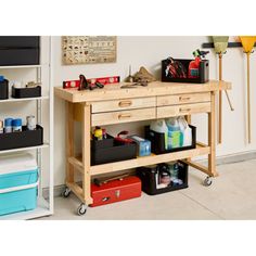 a workbench with tools and other items on it in front of a wall