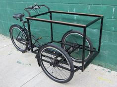 a bicycle is parked in front of a green wall with bars attached to the back