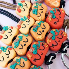 several cookies shaped like people with faces on them are sitting next to some key chains