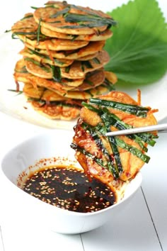 a bowl filled with food sitting on top of a white table next to a pile of pancakes