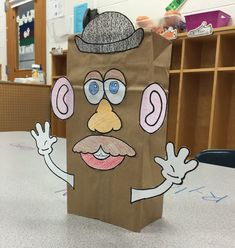 a brown paper bag with a drawing of a man's face on it and hands in the air