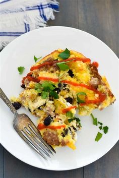 a white plate topped with an omelet and a fork