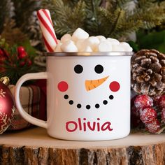 a white mug filled with marshmallows sitting on top of a wooden table