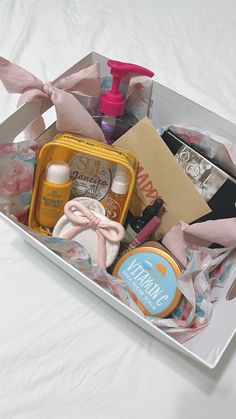 an open gift box with personal care items in it on a white sheeted surface