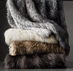 three furs stacked on top of each other in different colors and sizes, one is grey