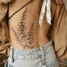 the back of a woman's stomach with flowers tattooed on her lower back and side