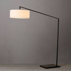 a lamp that is sitting on top of a wooden table next to a gray wall