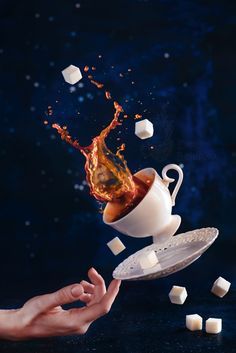 someone is pouring tea into a cup with marshmallows falling out of it