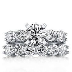 a wedding ring set with two rows of diamonds on top of each band and the center diamond