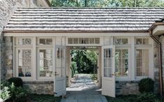 an open door leading into a stone building with white windows and doors on both sides