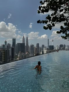 a person in a swimming pool with cityscape in the background