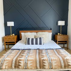 a bed with two nightstands next to it and a wall painted in dark blue