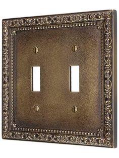 an ornate metal switchplate cover with two toggles on the front and back