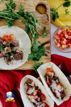 three tacos with meat and vegetables on a cutting board next to a bowl of salsa