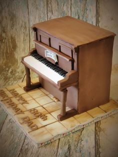 a cake shaped like a piano on top of a wooden table next to a wall