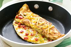 an omelet with cheese and tomatoes in a pan