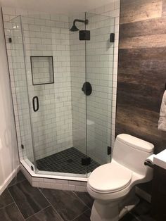 a white toilet sitting next to a walk in shower