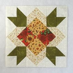 a patchwork quilt with flowers and leaves on the center, as if it were an ornament