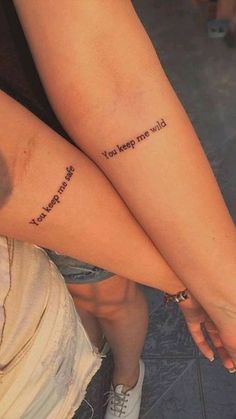 two people with matching tattoos on their legs that say, you keep me wild and they are