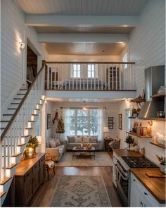 a living room filled with furniture and a stair case next to a kitchen counter top