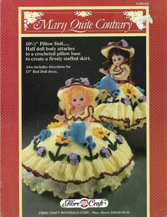 two dolls in yellow dresses and hats with flowers on the bottom, one is wearing a hat